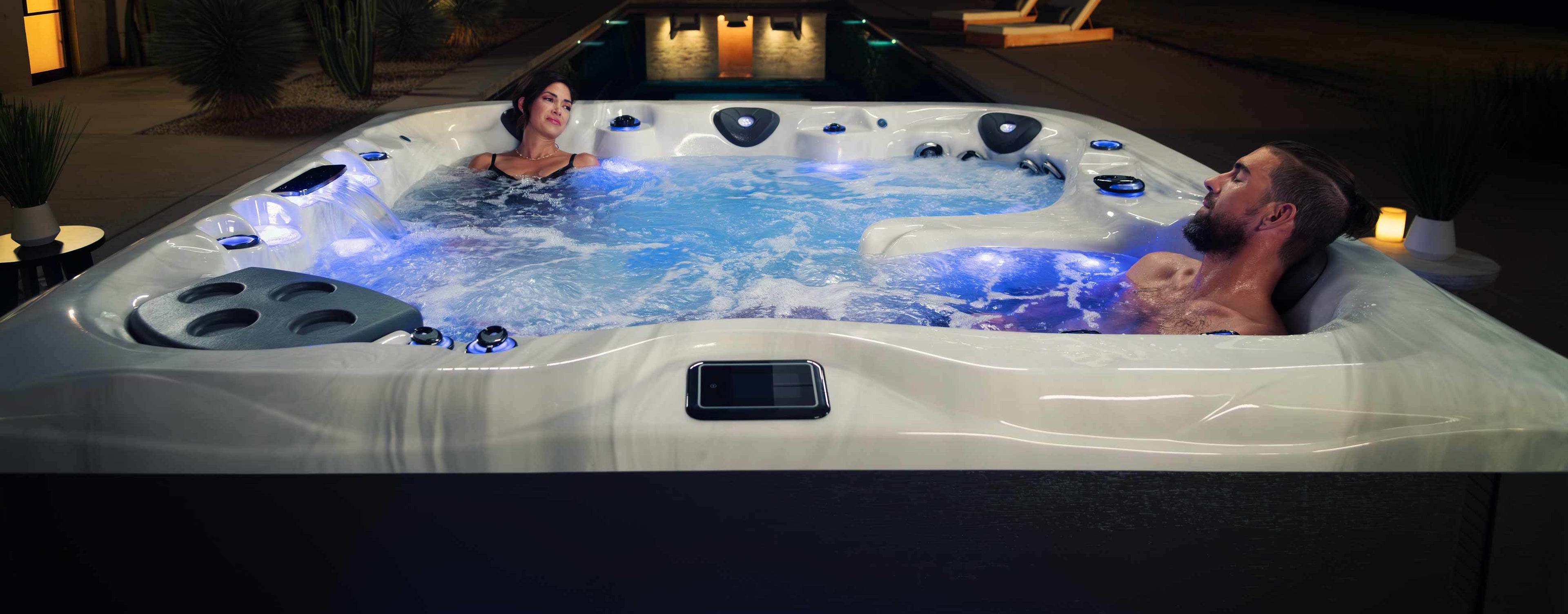 Two people relaxing in a hot tub with illuminated interior